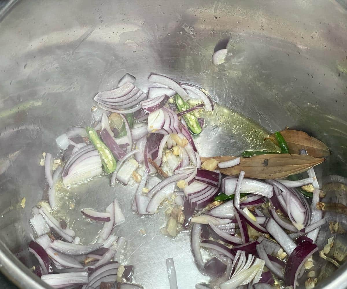 Sliced onions sautéed with spices and fresh cilantro in the Instant Pot for matar pulao.