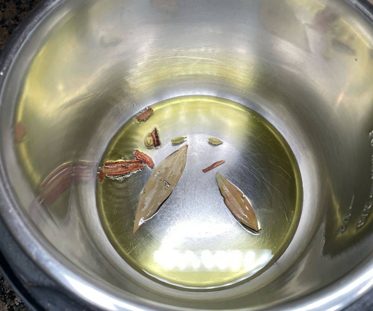 Whole spices are in the hot oil for instant pot Matar pulao.