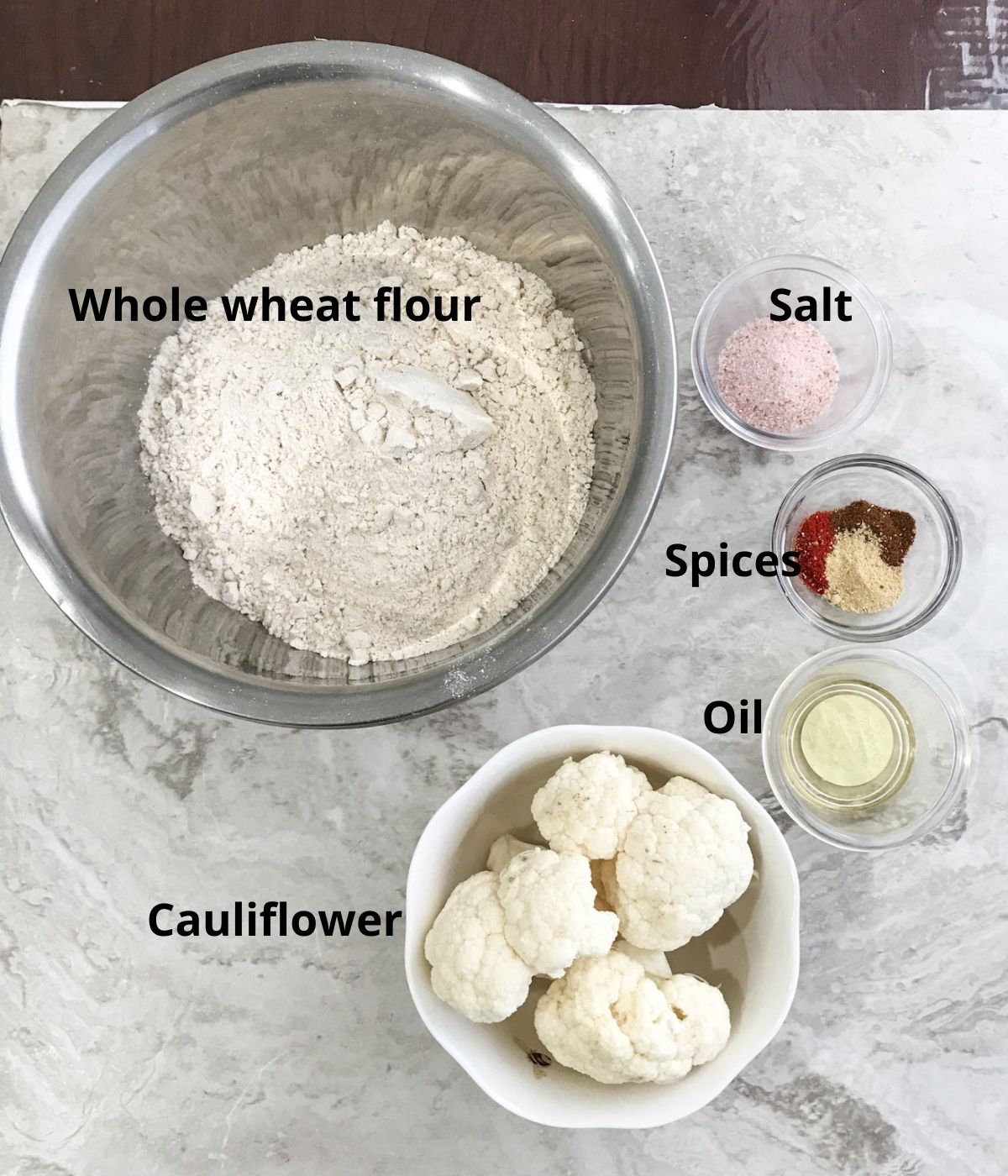 All the ingredients like flour,cauliflower and spices are placed on the flat surface for paratha