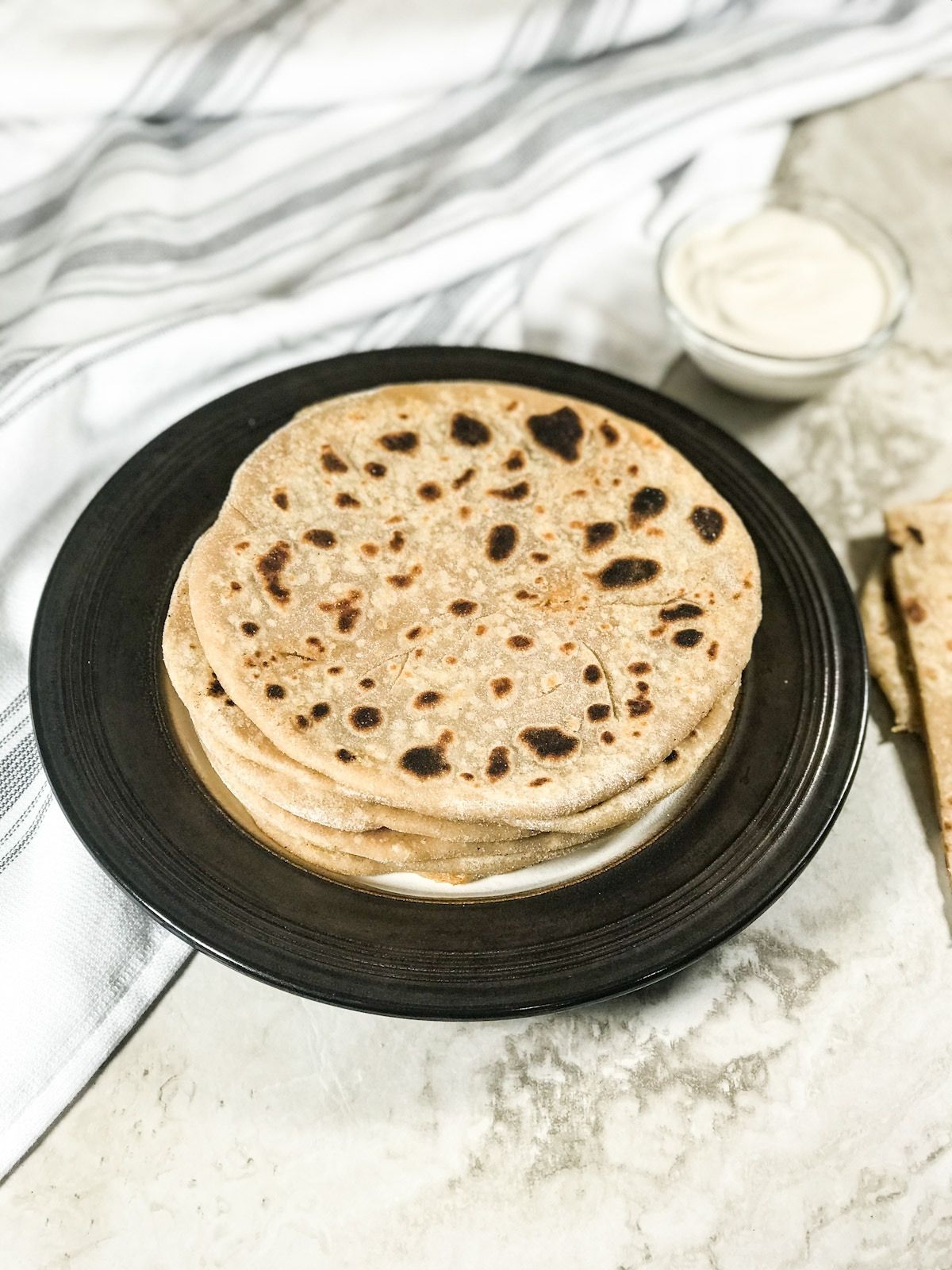 A plate of stacked gobi paratha is on the table