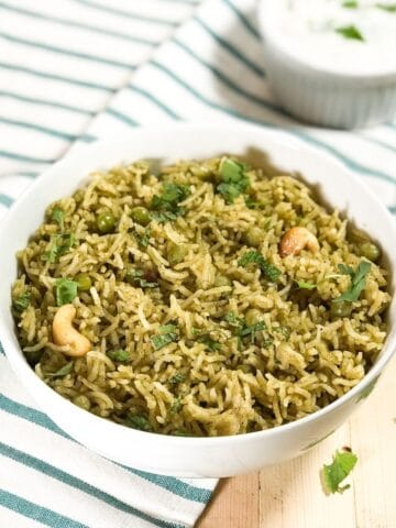 A bowl is with matar pulao and topped with cilantro