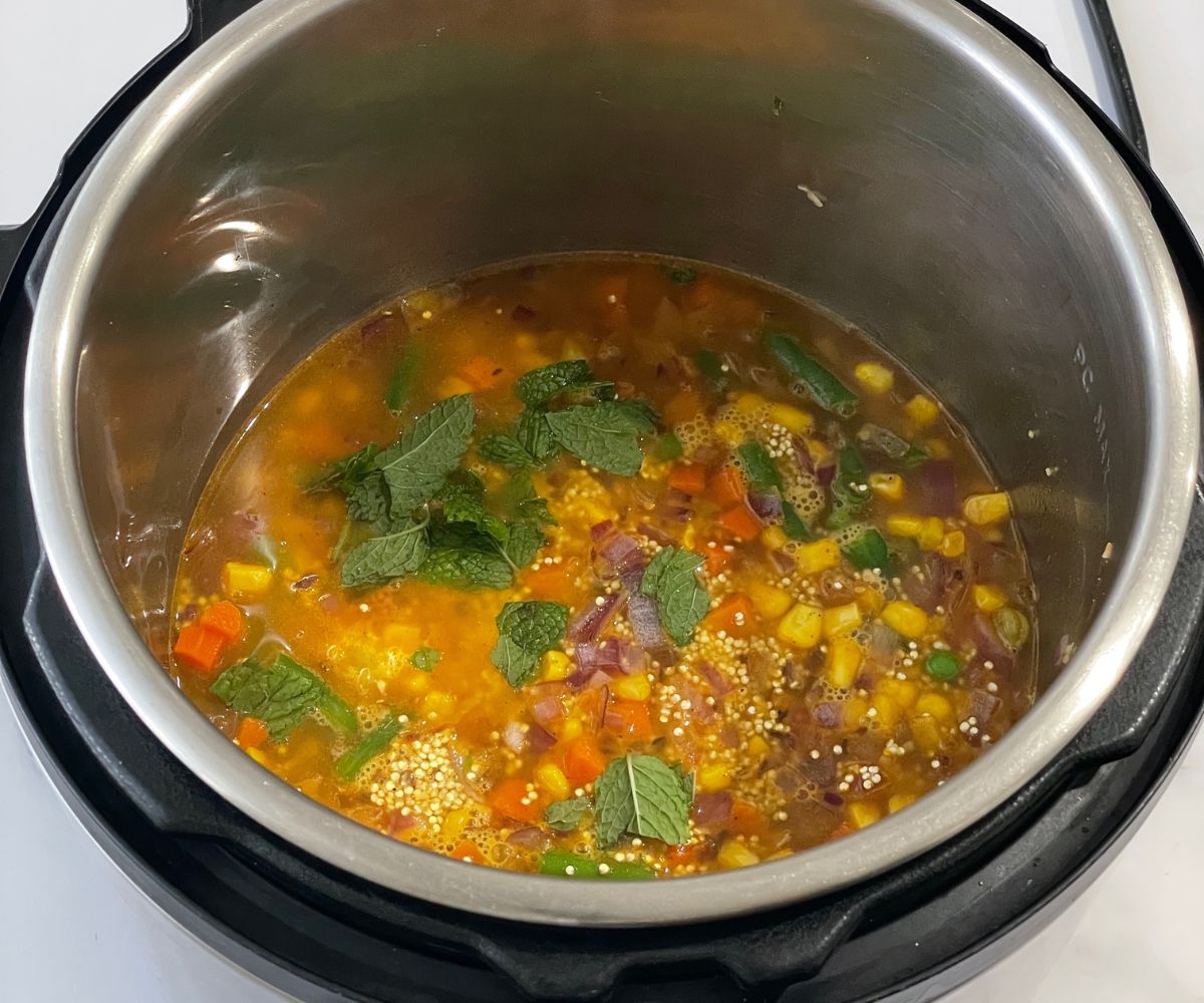 A pot is with uncooked quinoa pulao mixture.