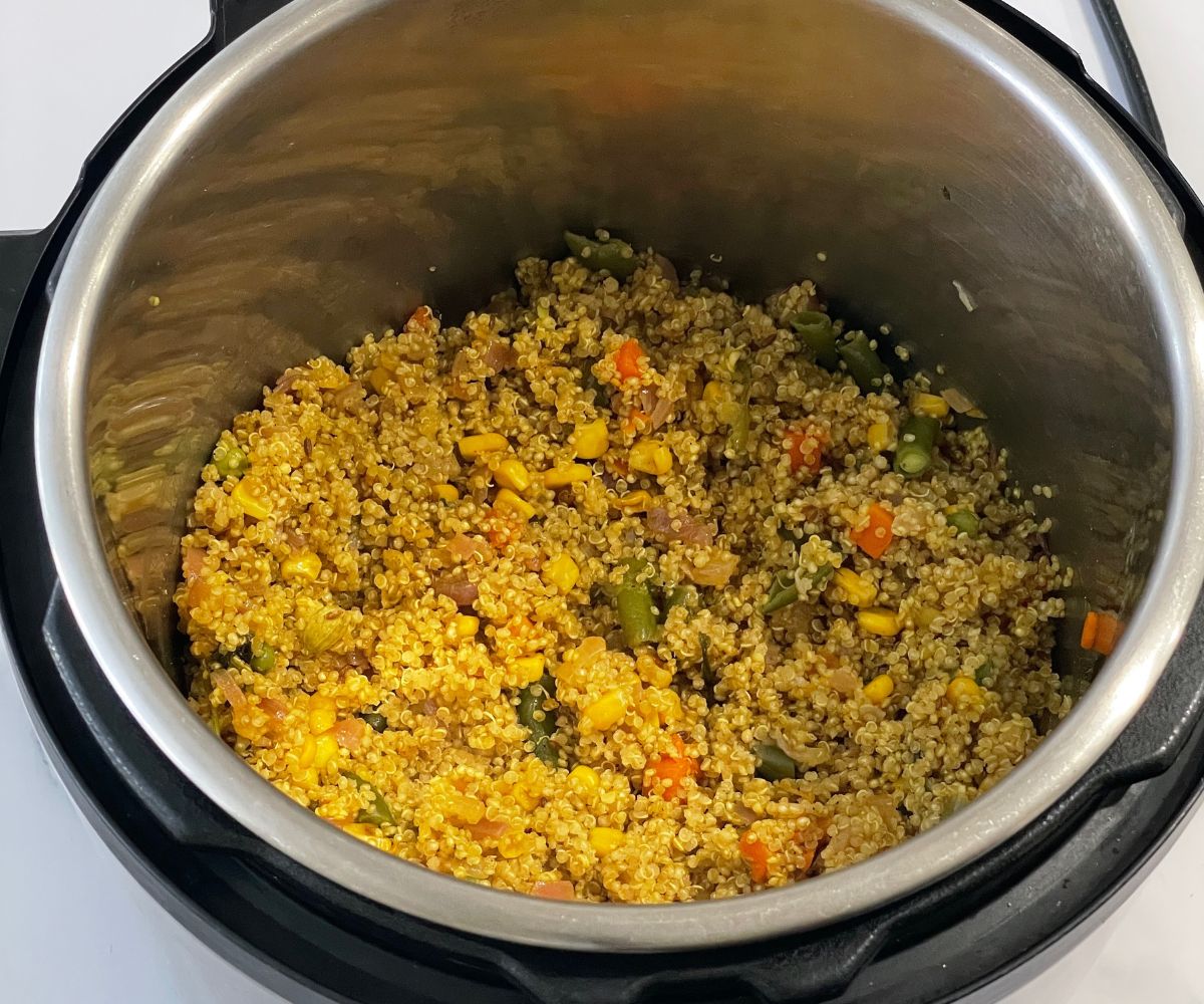 An instant pot is with quinoa pulao on the table.