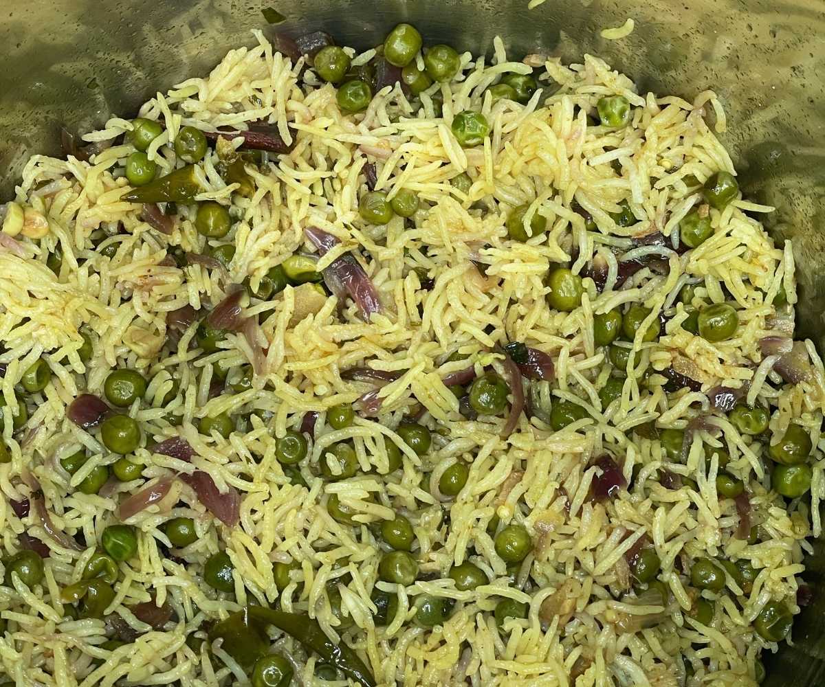 An Instant pot is filled with peas pulao rice dish.