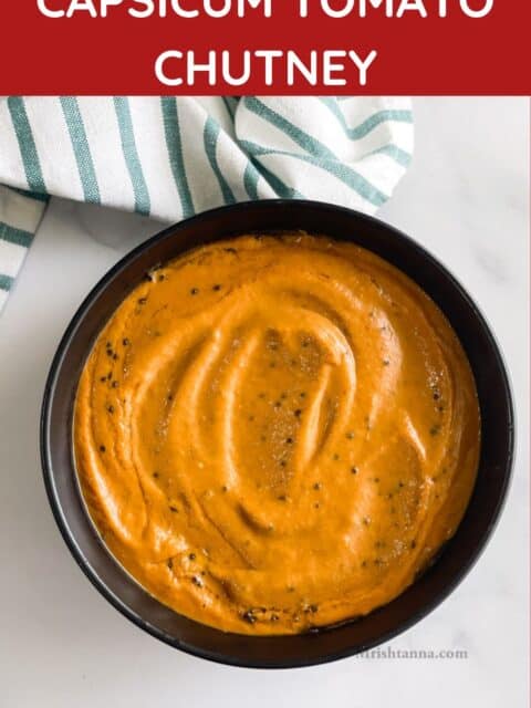 A black bowl is with capsicum chutney on the table.