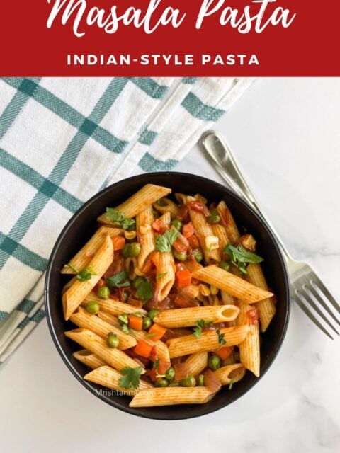 A bowl of masala pasta is on the marble table.