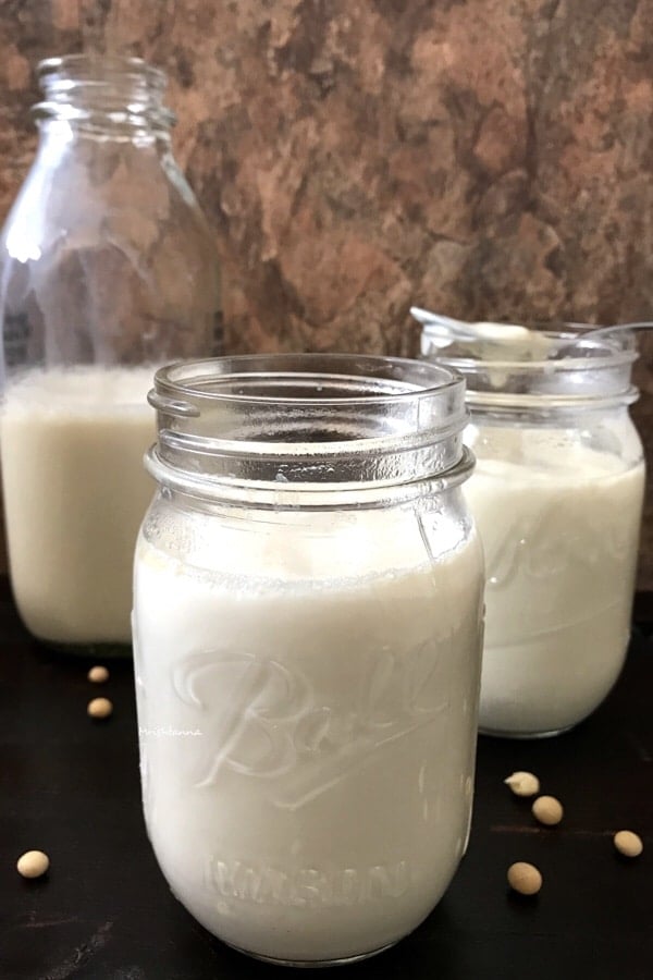 A glass of milk on a counter, with Soy yogurt
