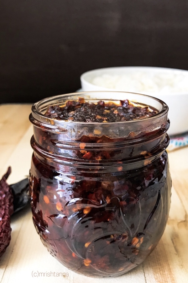 A jar is filled with Szechuan hot sauce is on the table