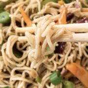 a man is holding rice noodles in chopsticks