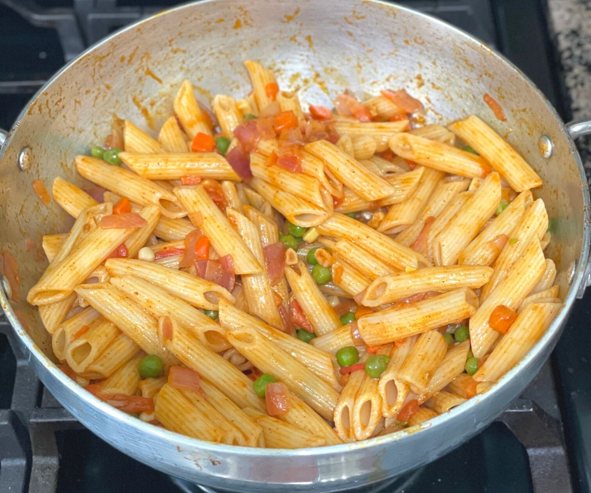 A pot is with desi masala pasta over the heat.