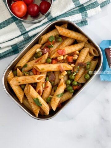 A lunch box is filled with masala pasta.