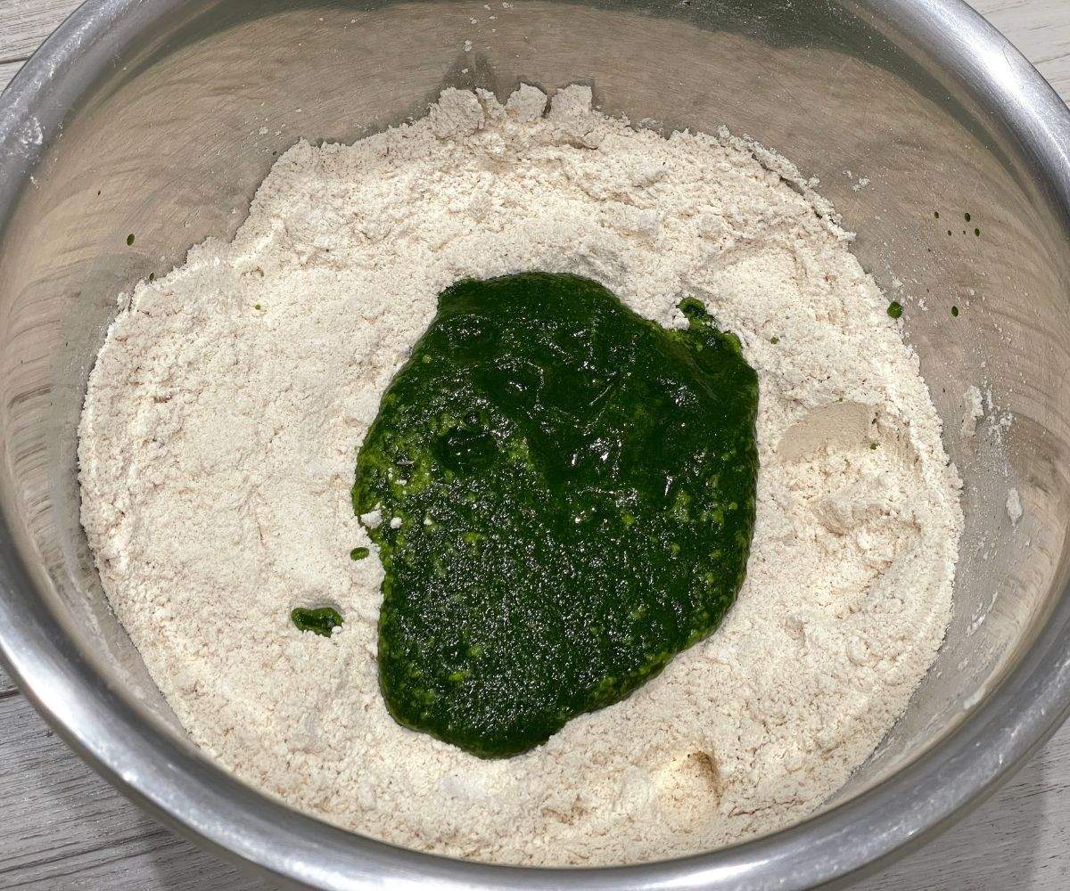a large bowl is with flour and spinach puree.