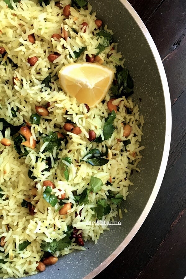 A pan is filled with  Lemon Rice and topped with cilantro and lemon slice