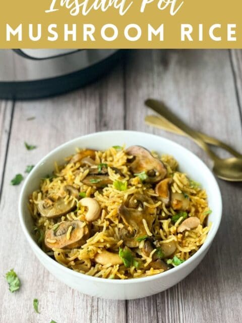 A bowl of mushroom rice is on the table with two spoons by the side