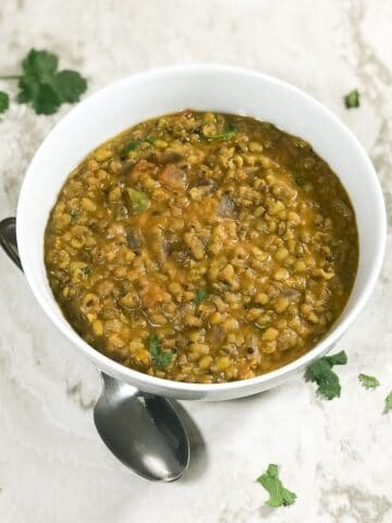 A bowl is with green gram dal is on the table