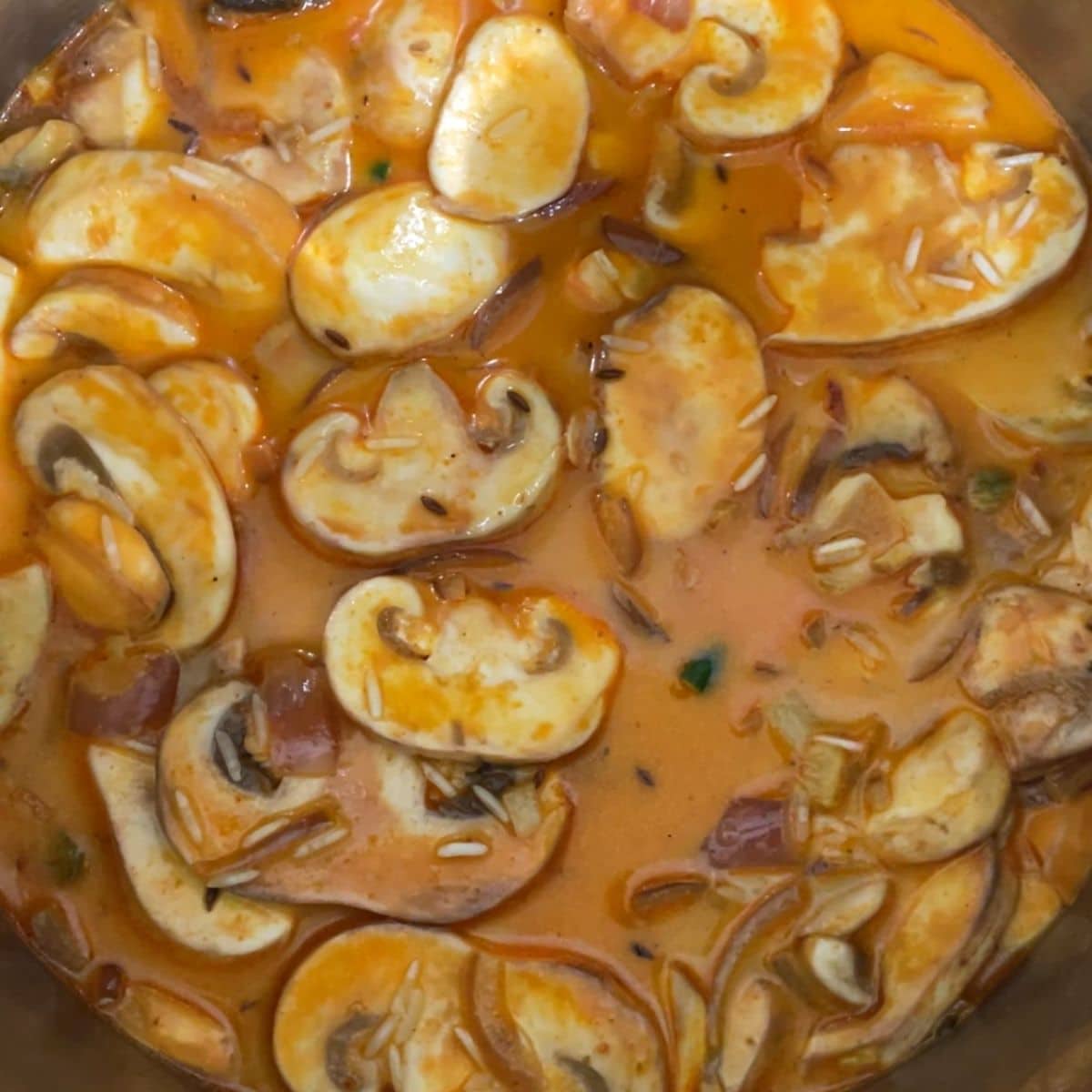 a pot is with mushroom, rice and water