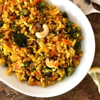 A plate with spiced poha on the table