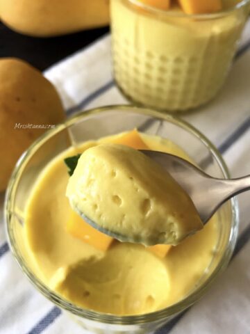 A bowl of mango mousse is on the table