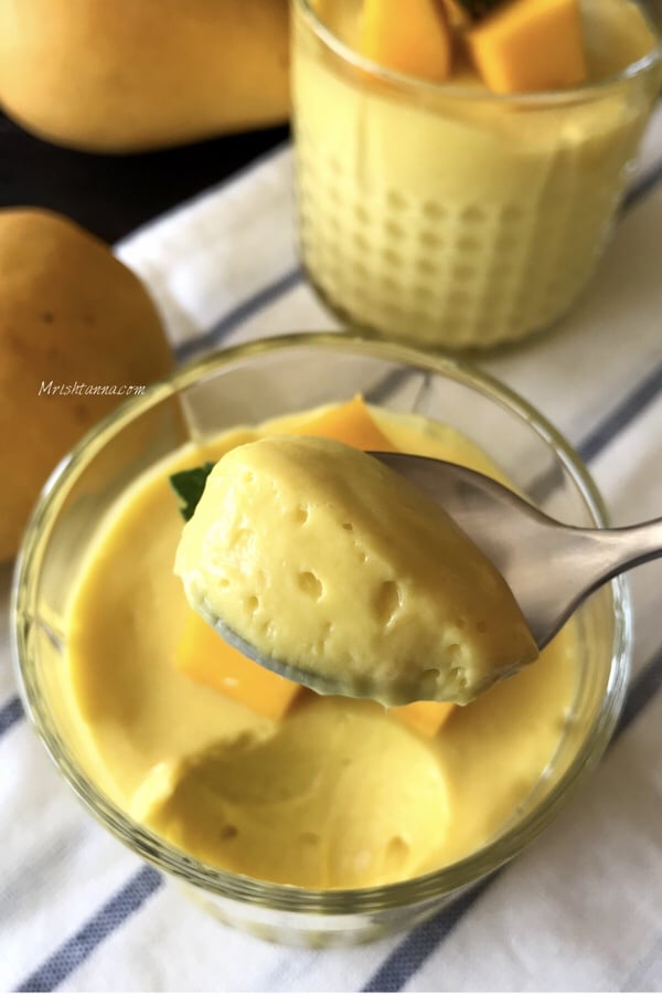 A bowl of mango mousse is on the table