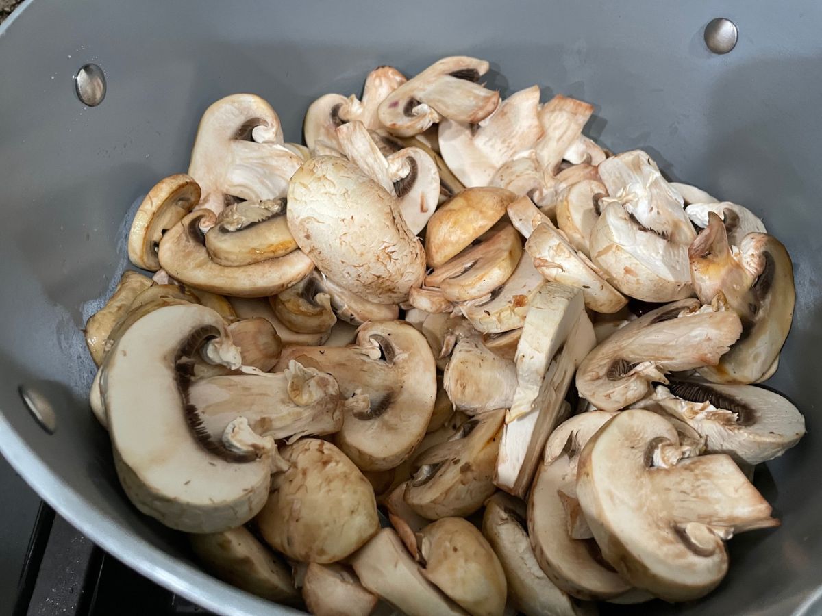 A medium size pan is with mushrooms over the heat