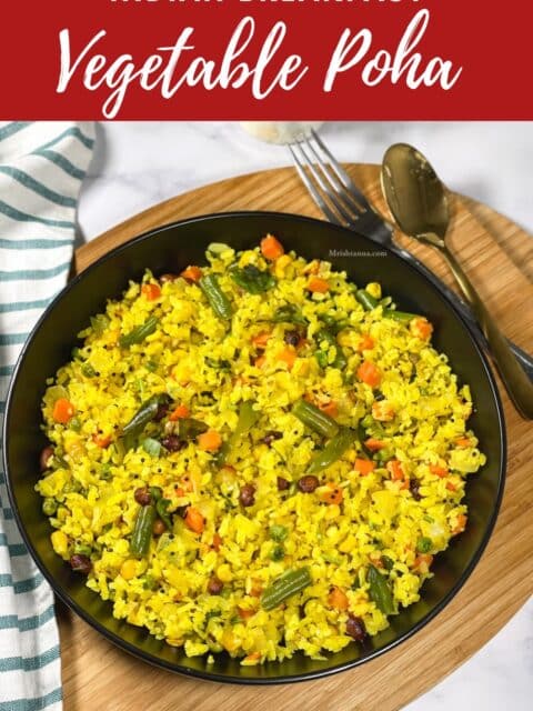 A plate of mixed vegetable poha is on the tray with a spoon.