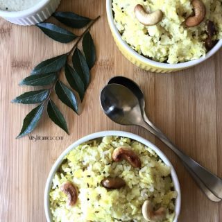 A bowl of Khara Pongal sitting on top of a wooden table.