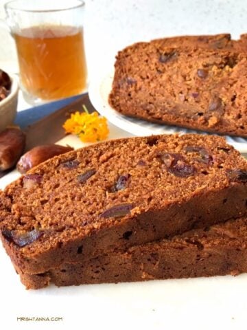 Two slices of mango bread on a plate, with dates