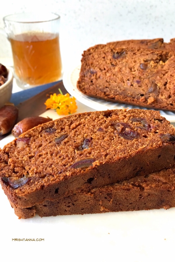 Two slices of mango bread on a plate, with dates