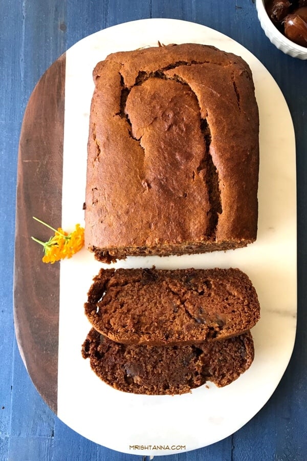 A mango dates cake bread loaf is on the white serving tray