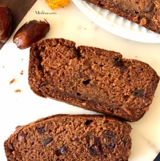 A piece of mango bread on a plate, with dates