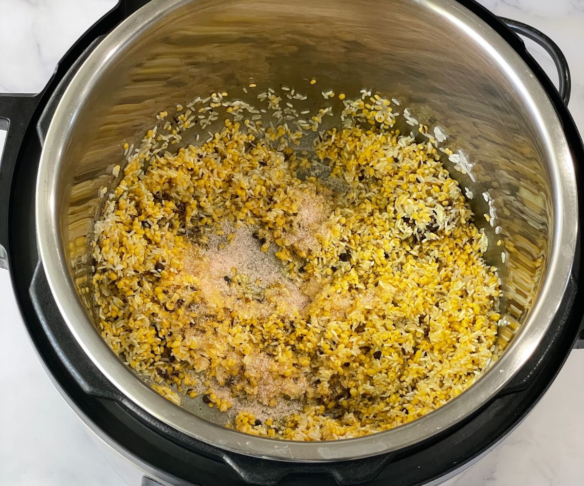 An instant pot is with rice and lentil for ponagl.