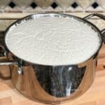 A steel vessel is filled with fermented dosa batter over the counter top.