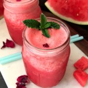 Watermelon juice is inside the glass jar and topped with mint leaves