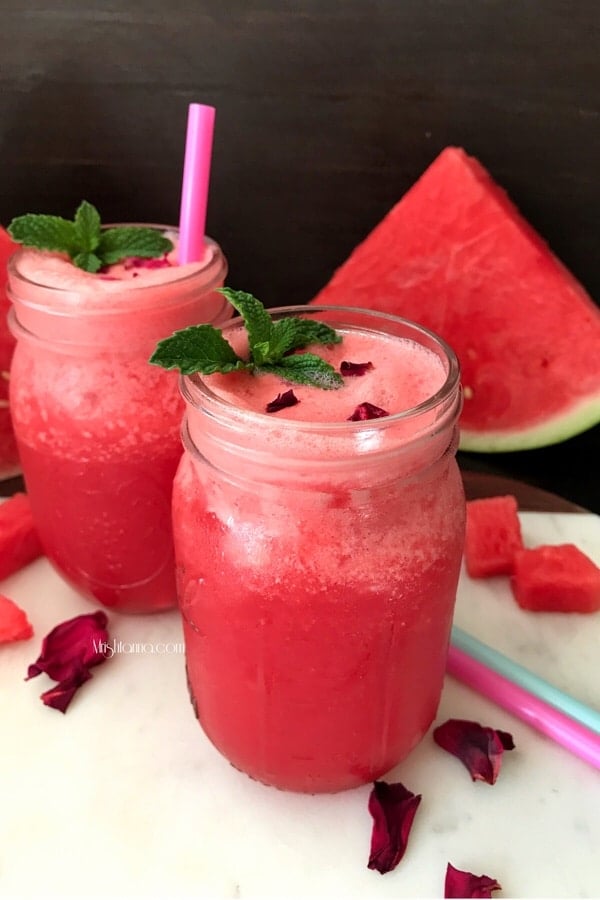A glass jar is filled with watermelon juice