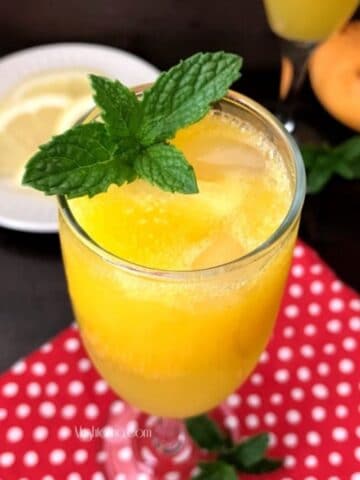 A glass of mango mock-tail is sitting on the table