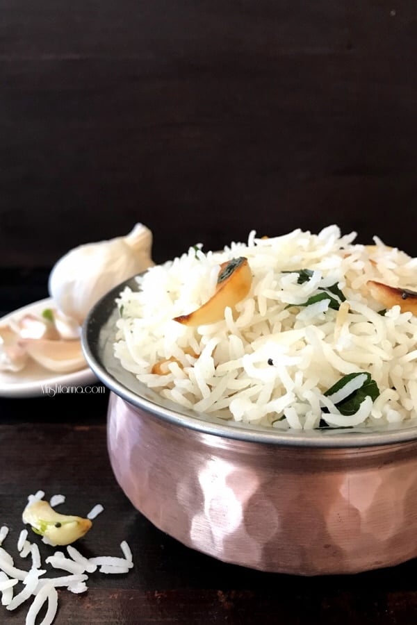 A bowl of food on a table, with garlic rice