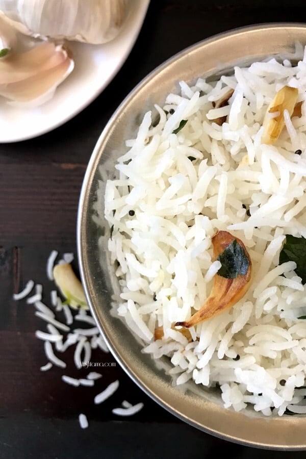 A bowl of food on a plate, with garlic rice