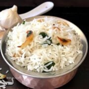 A bowl of food on a table, with garlic rice