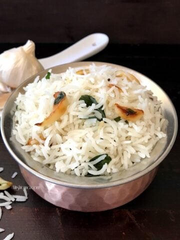 A bowl of food on a table, with garlic rice