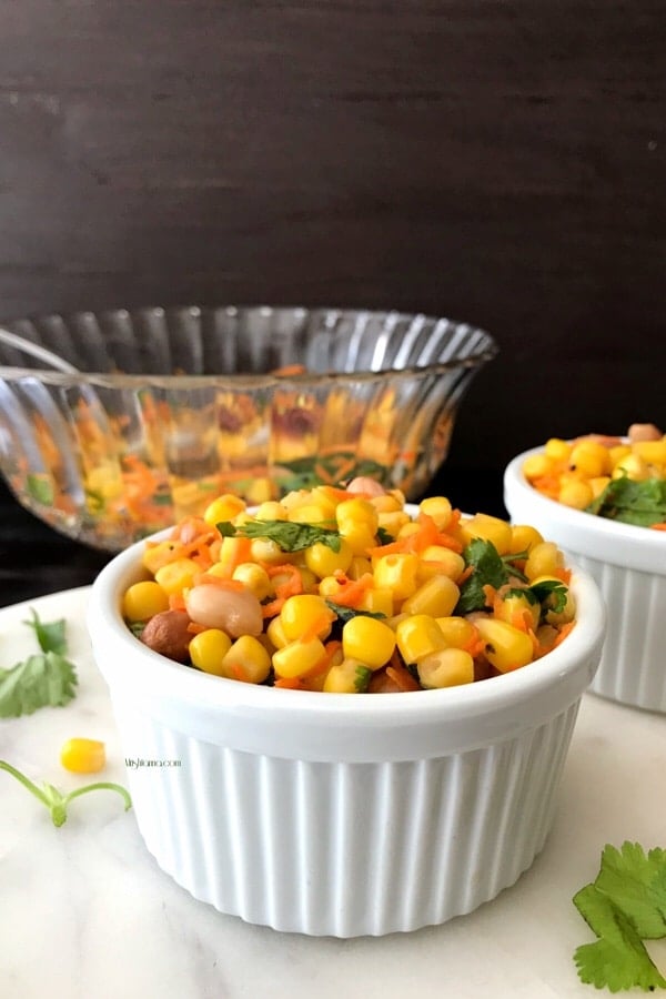 A bowl of food on a table, with Corn salad