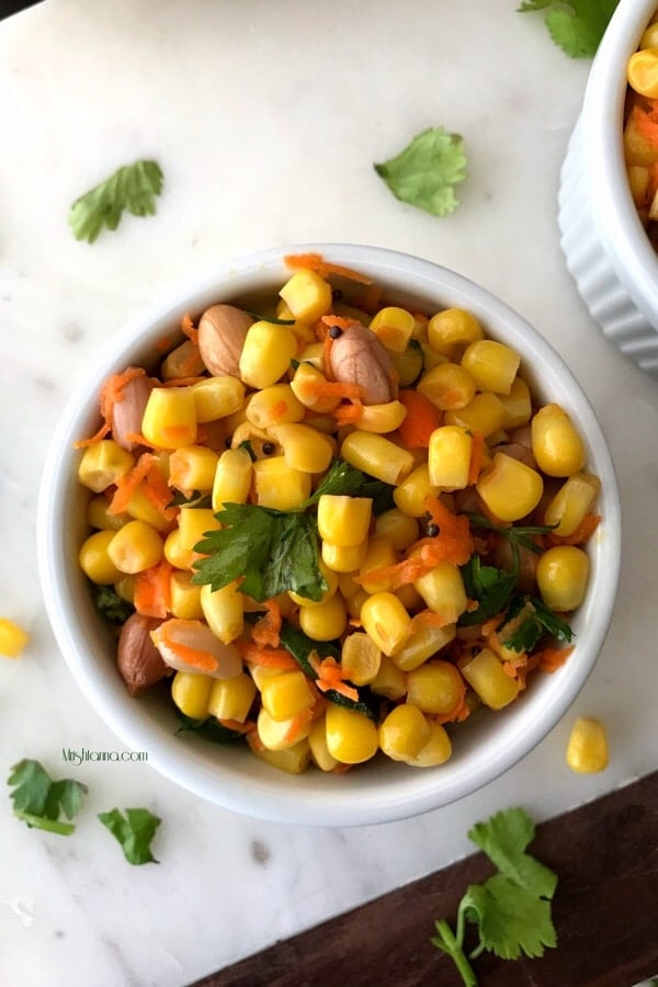 A bowl of salad on a plate, with Corn salad