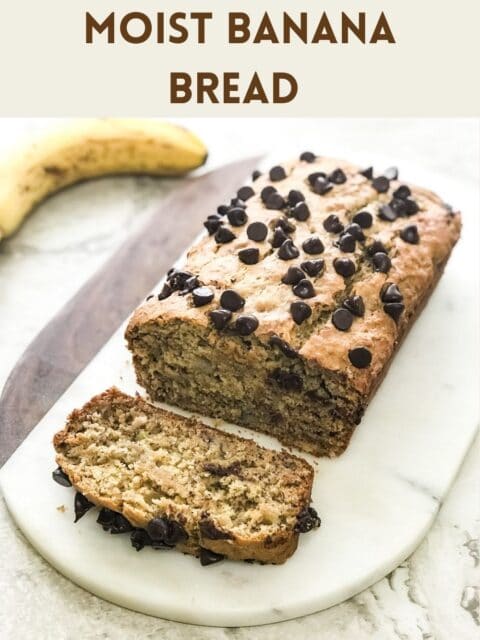 A banana bread loaf is on the white serving tray