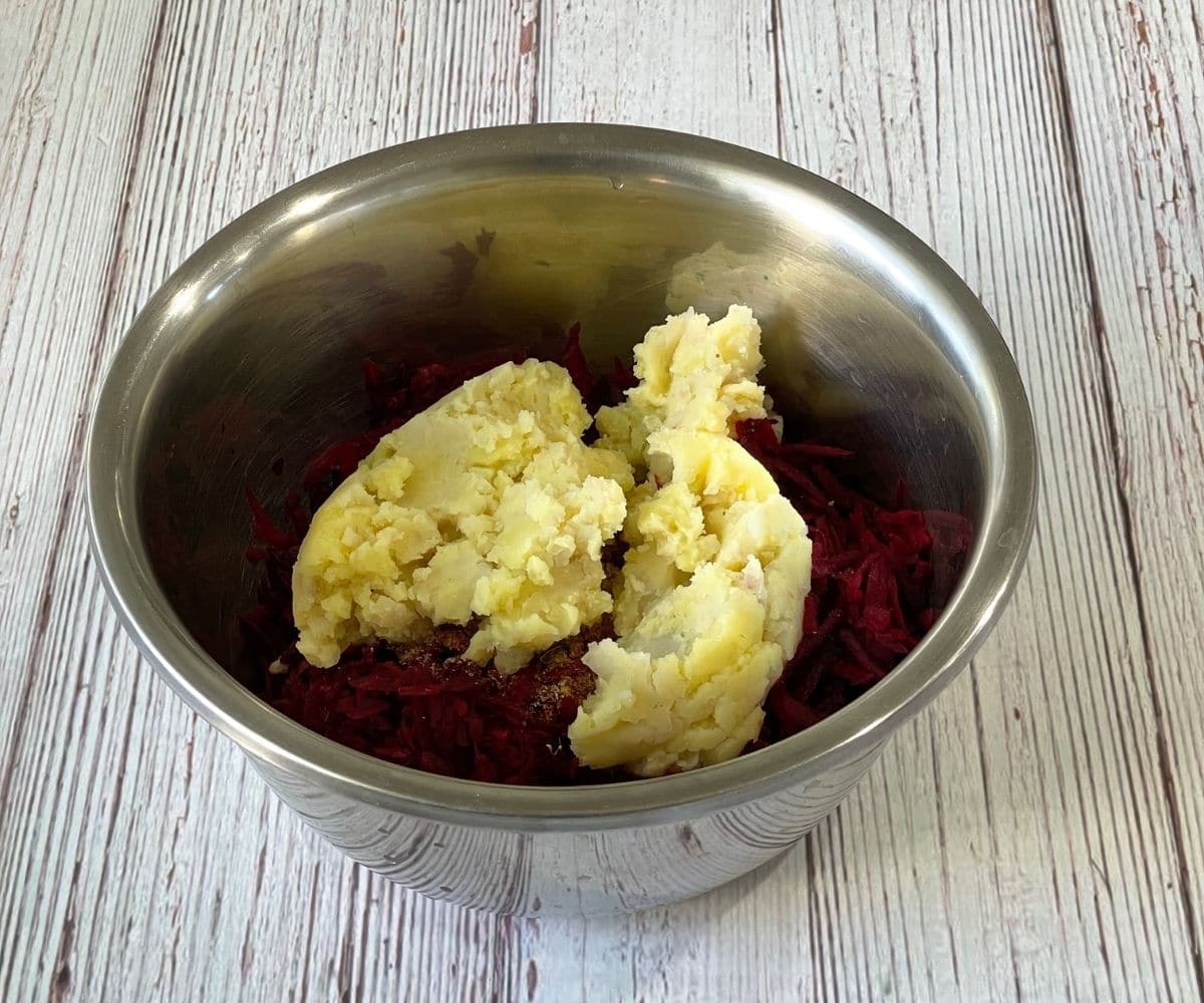 A bowl is with beets and mashed potatoes. 