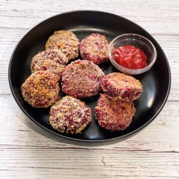A plate of beetroot cutlets are on the table.