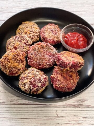 A plate of beetroot cutlets are on the table.