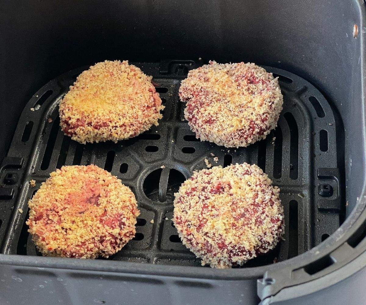 Beetroot cutlets are placed inside the air fryer basket.