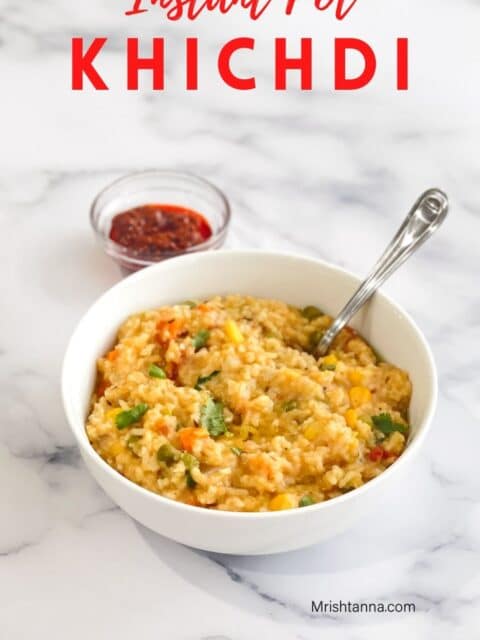 A bowl of khichdi with spoon is on the table.