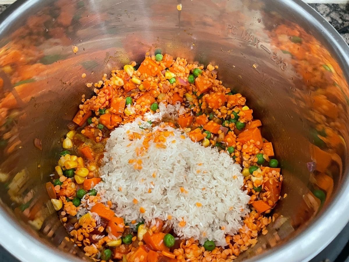 A pot is with lentils, rice and vegetables for khichdi.