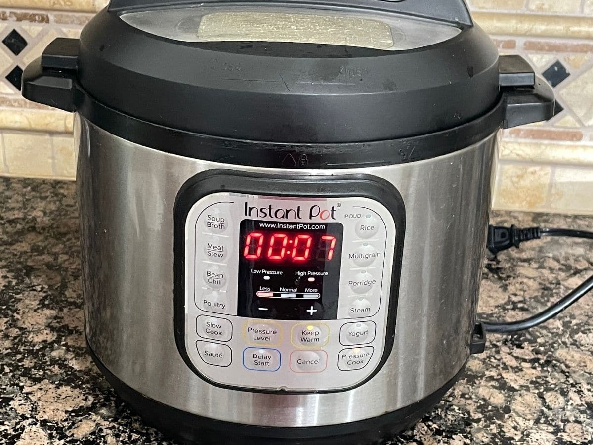 An instant pot is displaying cooking time on the counter.