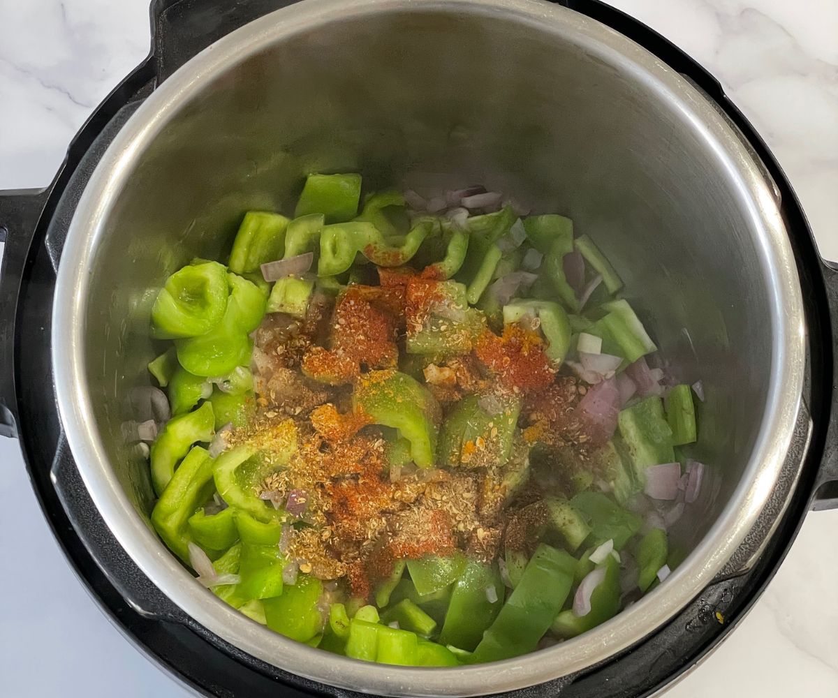 A pot is with bell peppers and spices on saute mode.